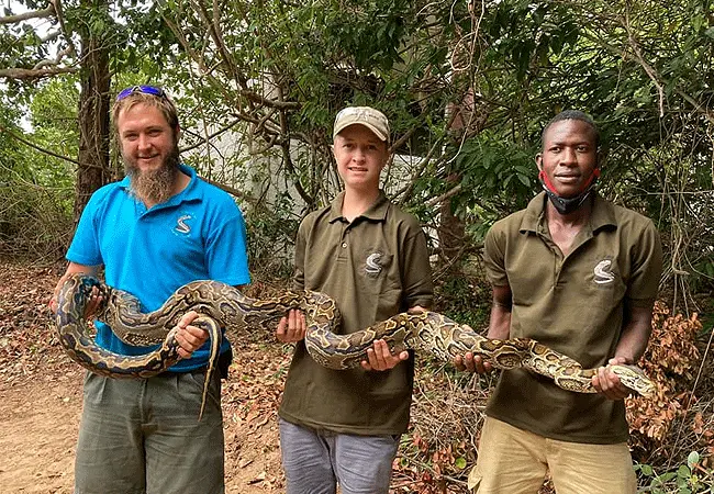 Keepers holding a python at Bio-Ken snake farm