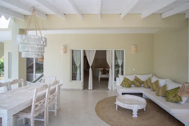 The dining table and lounge under a beamed ceiling
