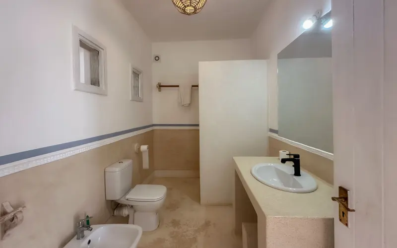 A bathroom with a long vanity