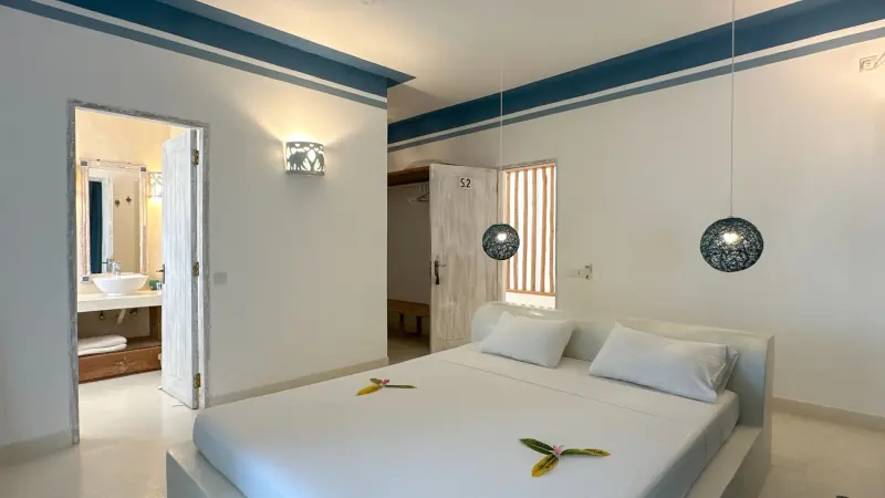 A bright bedroom with a blue painted beam
