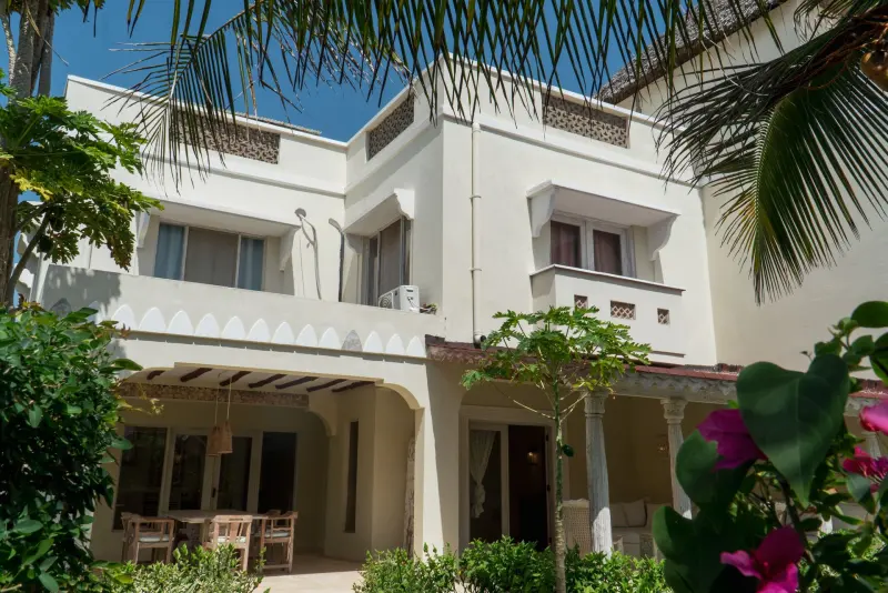 The villa’s white façade among the palms