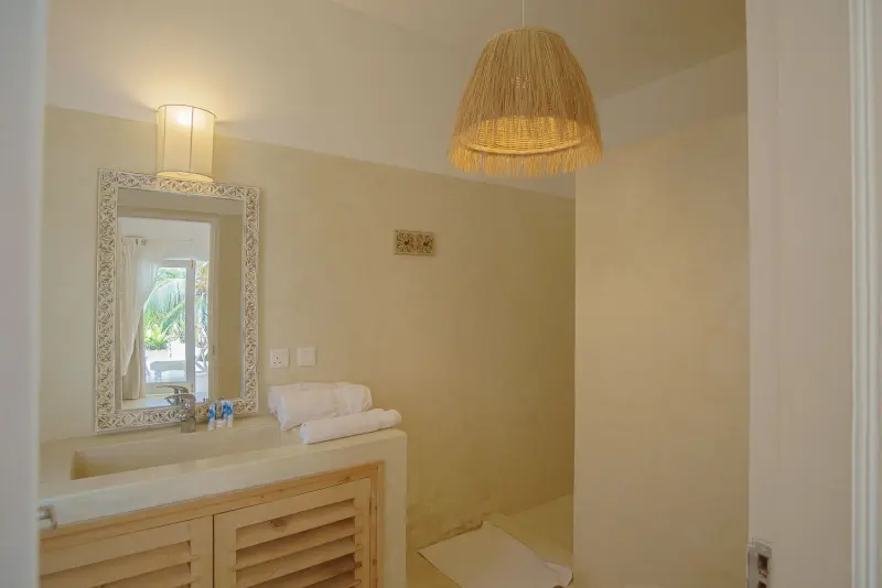 A bathroom with a shell mirror