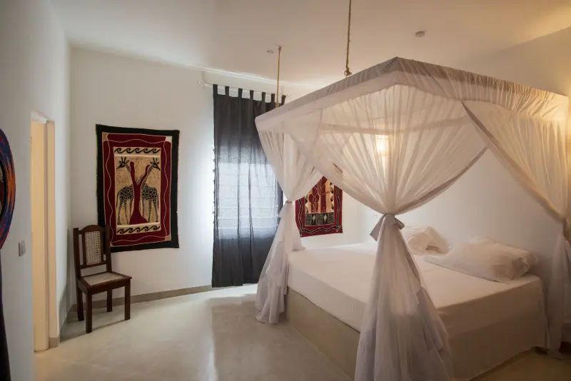 A four-poster bed with white nets