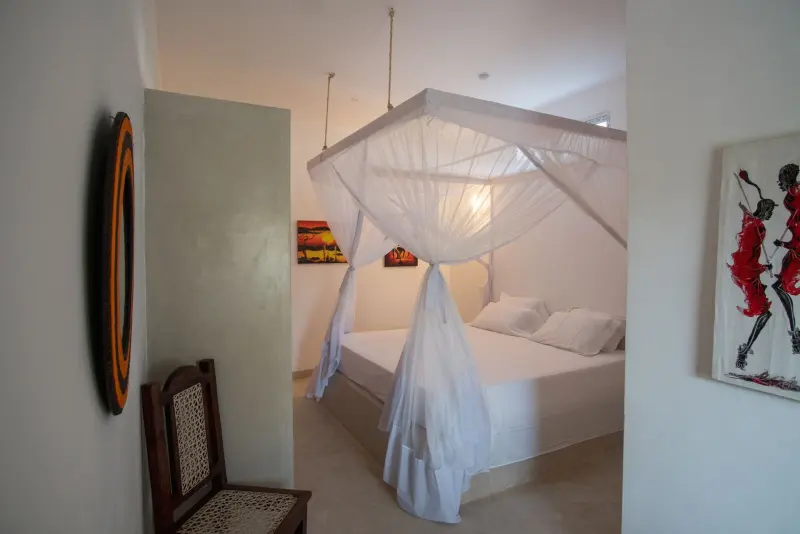 A bedroom with a round mirror and white net