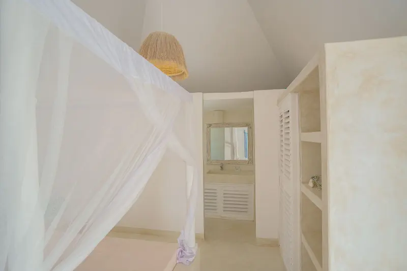 A bedroom with a net-draped bed